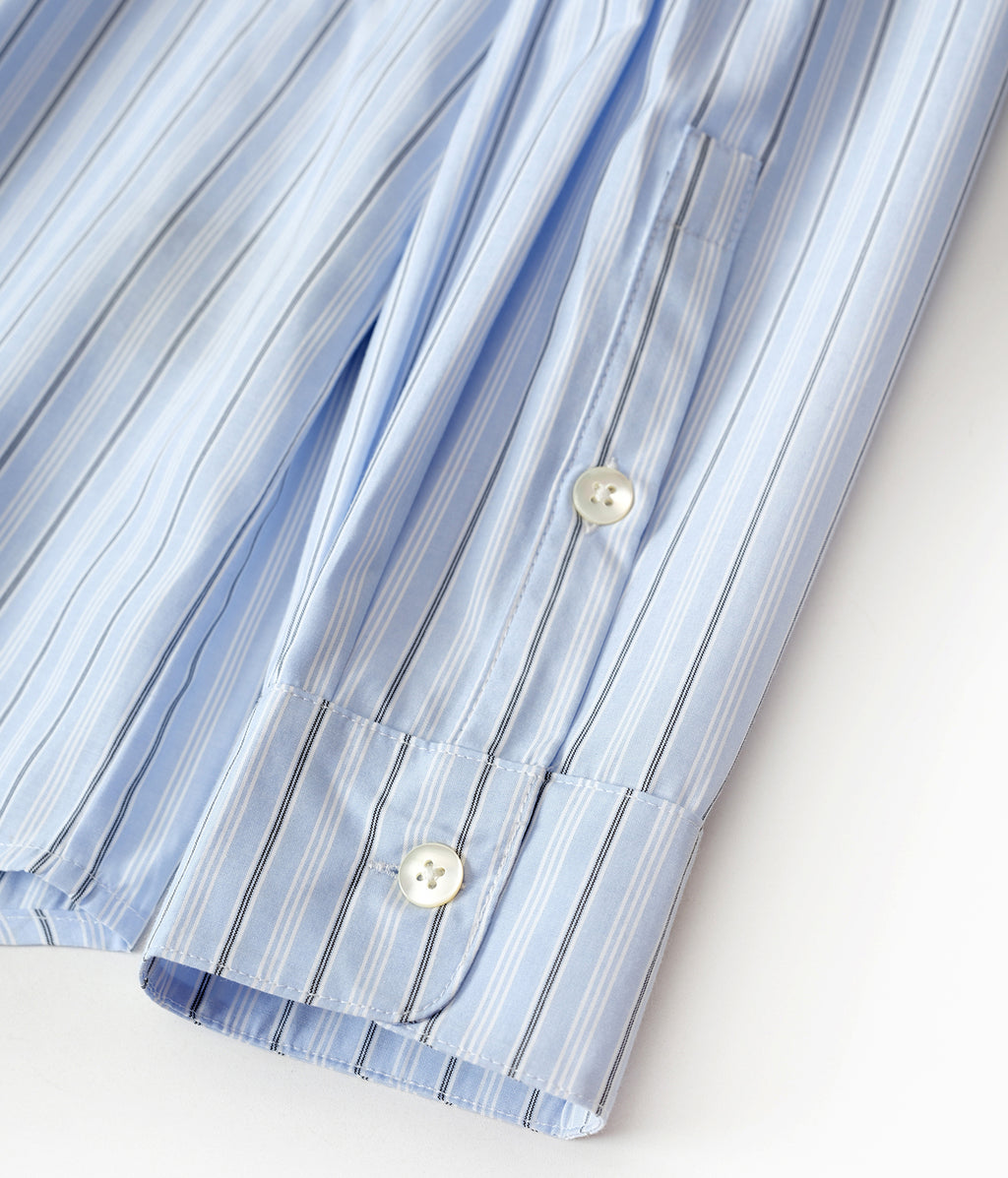 Close-up of a blue and white striped shirt with buttons on a light background